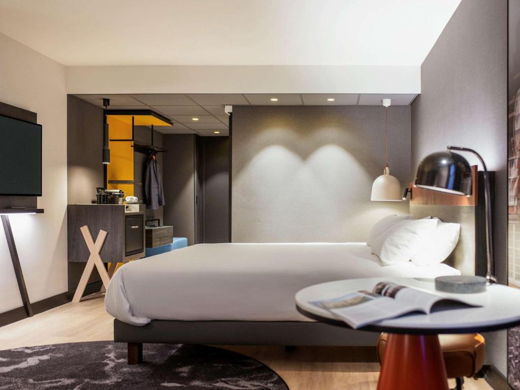 阿姆斯特丹Mercure Amsterdam City Hotel的一间卧室配有一张大床和一张桌子