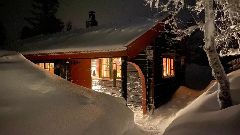 斯朱森Bjerkely, Sjusjøen的雪覆盖的小屋,设有红色屋顶