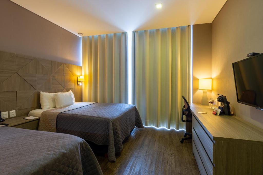 莱昂格罗蓬特酒店 - 穆尔扎的酒店客房设有两张床和电视。