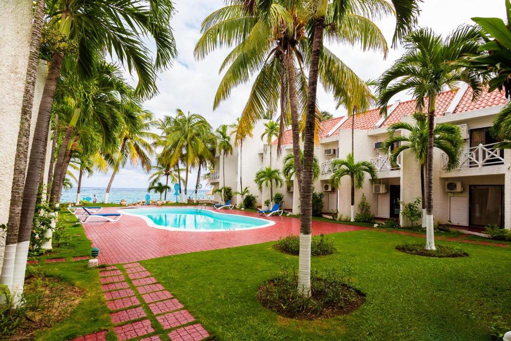 圣玛丽Chrisanns Hidden Cove 2 bedroom的一座带游泳池和棕榈树的度假村的形象