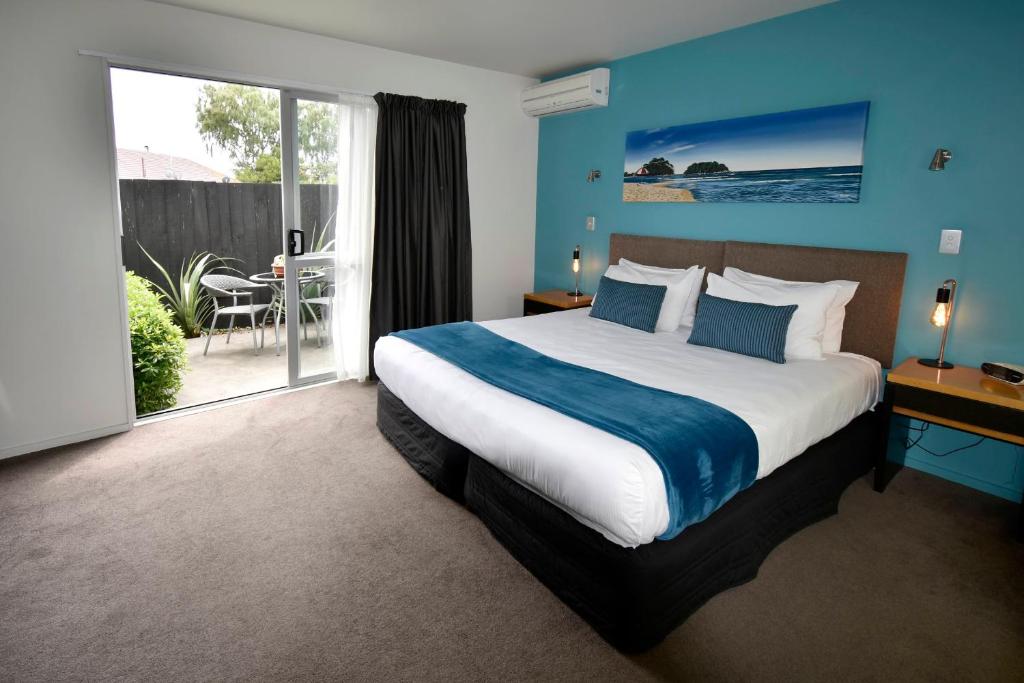 基督城瑞卡顿菲弗汽车旅馆的一间卧室配有一张带蓝色墙壁的大床