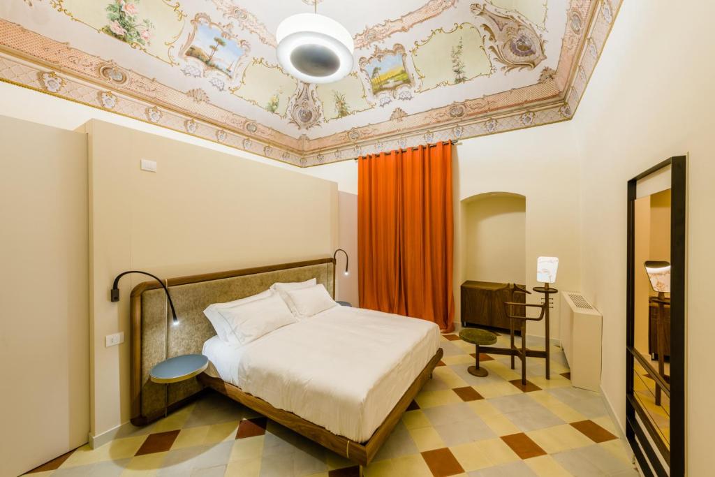 普蒂尼亚诺Dimora Clementina的一间卧室设有一张床和格子天花板