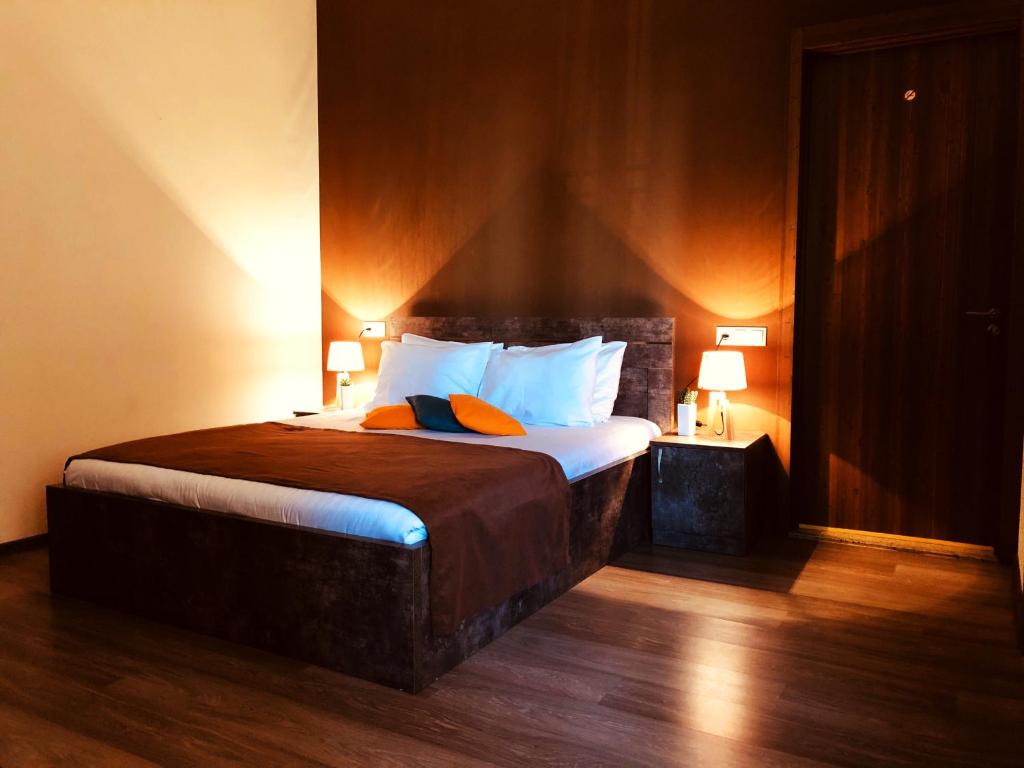 第比利斯Hotel Nabadi的一间卧室配有一张大床,上面有两盏灯