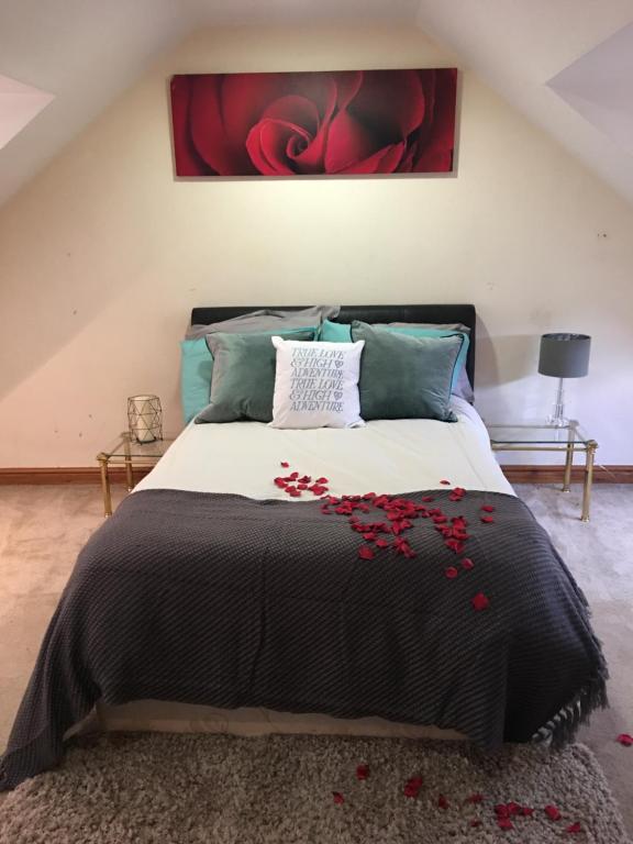 TyldesleyCastle House的一间卧室配有一张红色鲜花的大床