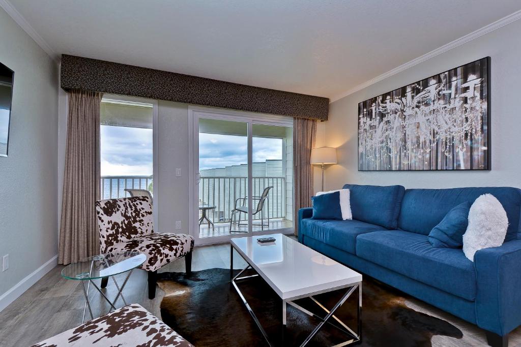 坦帕Fun and Functional Waterfront Condo - Heated Pool - WIFI的客厅配有蓝色的沙发和桌子