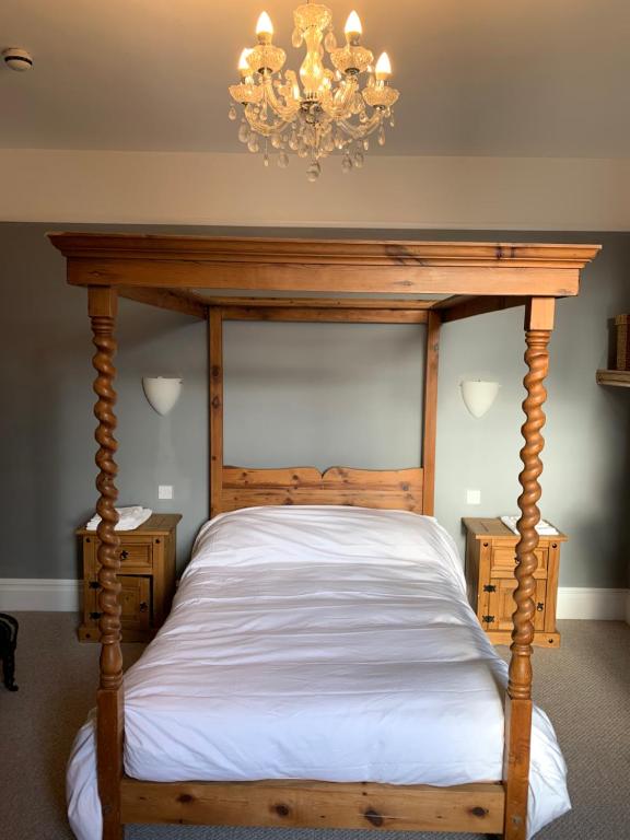 马基特德雷顿Lansdown House Bed & Breakfast的一间卧室配有一张木床和吊灯