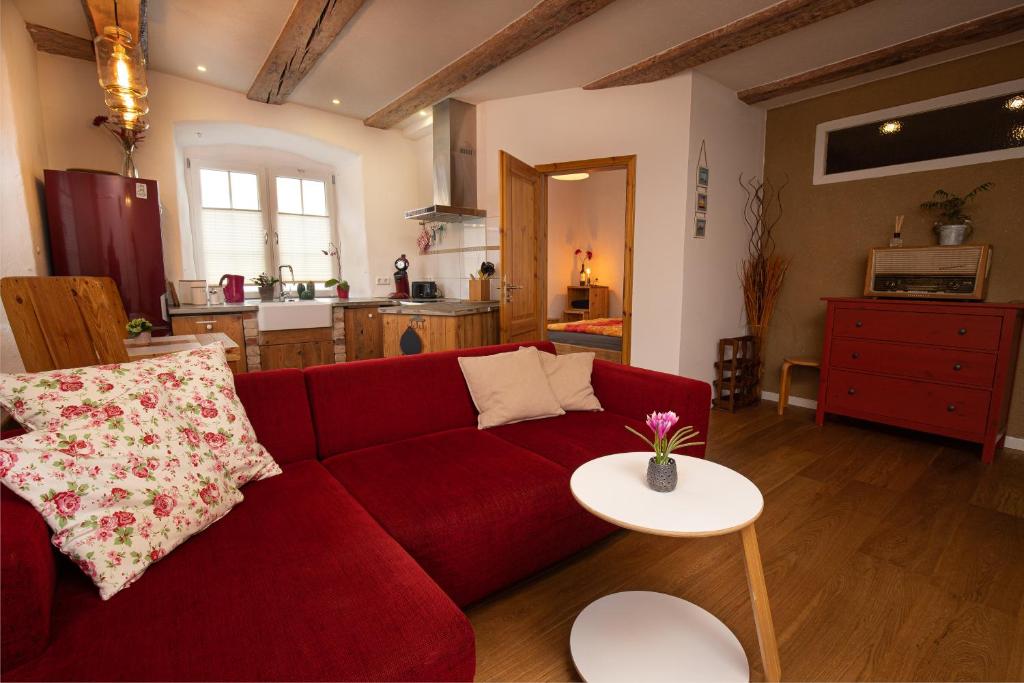 腓特烈港Am Lindenbaum的客厅配有红色的沙发和桌子