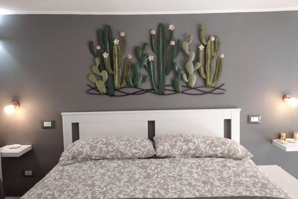 卡塔尼亚SISTO 85 - HOLIDAY HOUSE的卧室配有一张壁挂仙人掌的床
