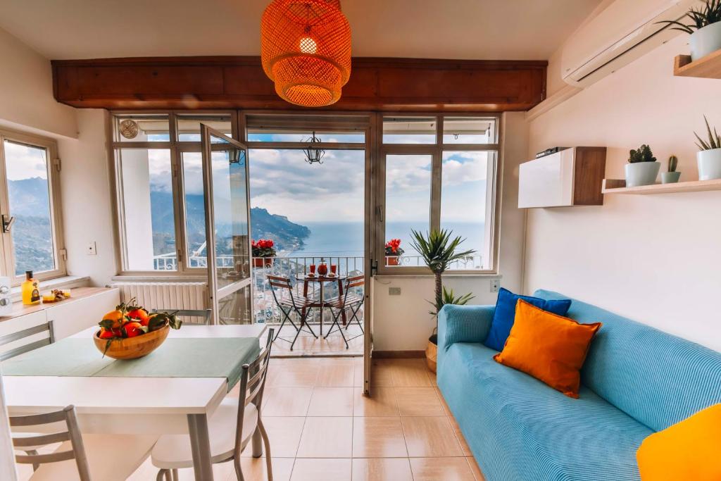 拉维罗CASA CHIARINA breathtaking sea view的客厅配有蓝色的沙发和桌子