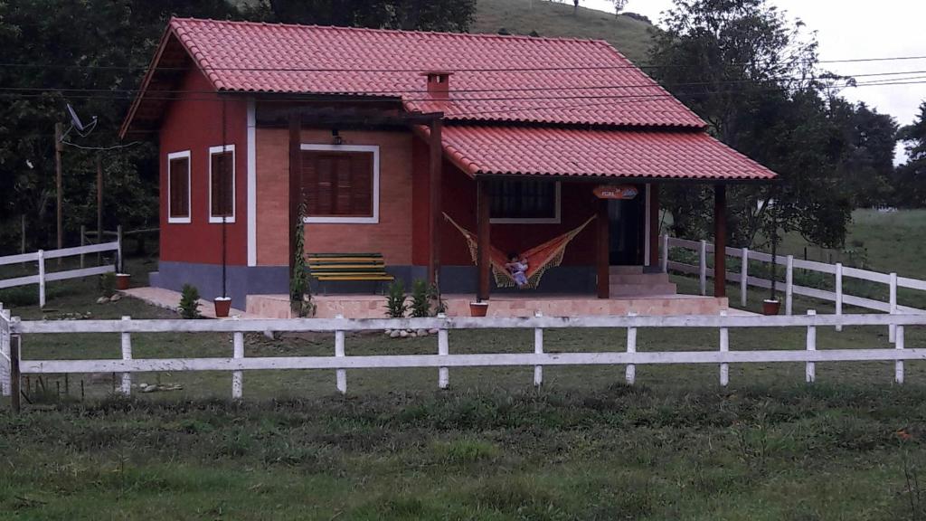 维奥康德马奥Encanto da Pedra的前面有白色围栏的红色房子