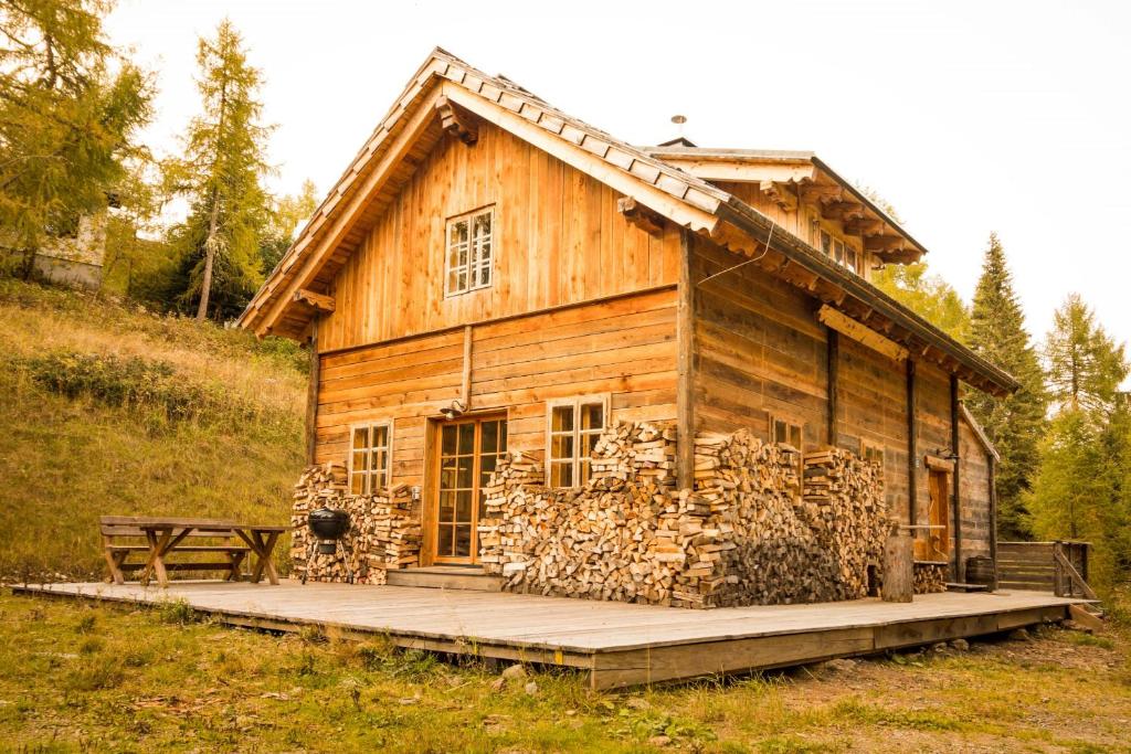 博登斯多夫Almhütte Chalet HIRSCHFISCH的小木屋前面有一堆木头