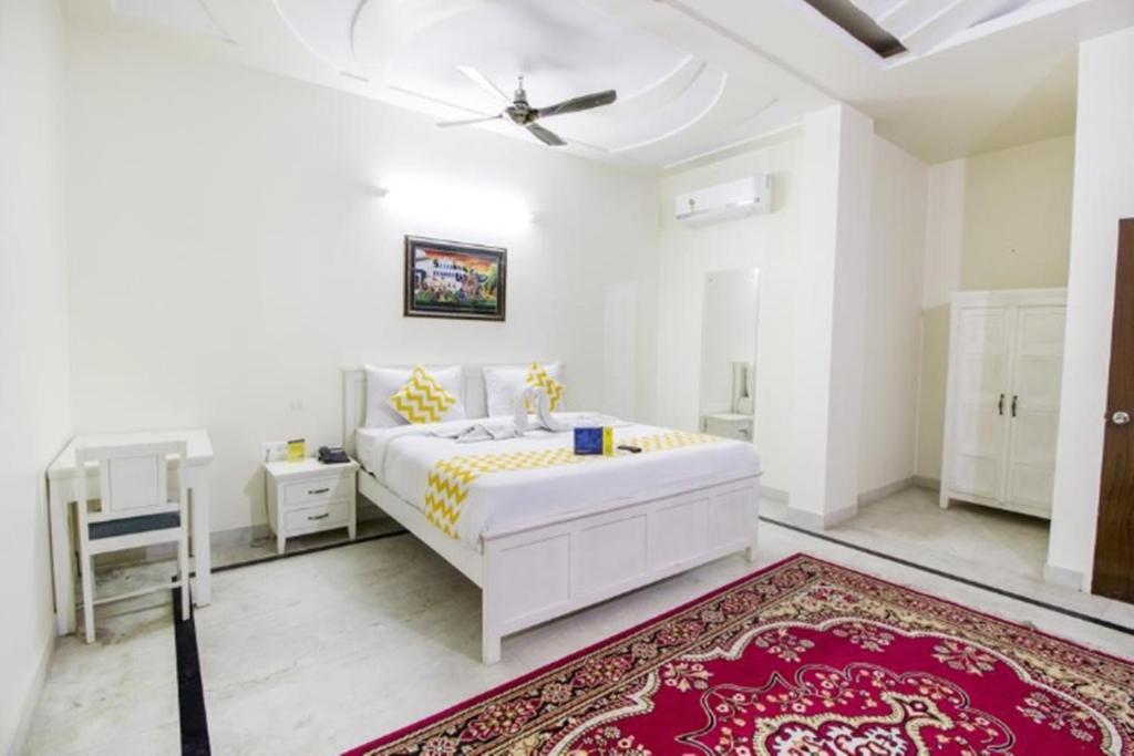 斋浦尔Hotel Dior Jaipur的白色卧室配有白色的床和红色地毯