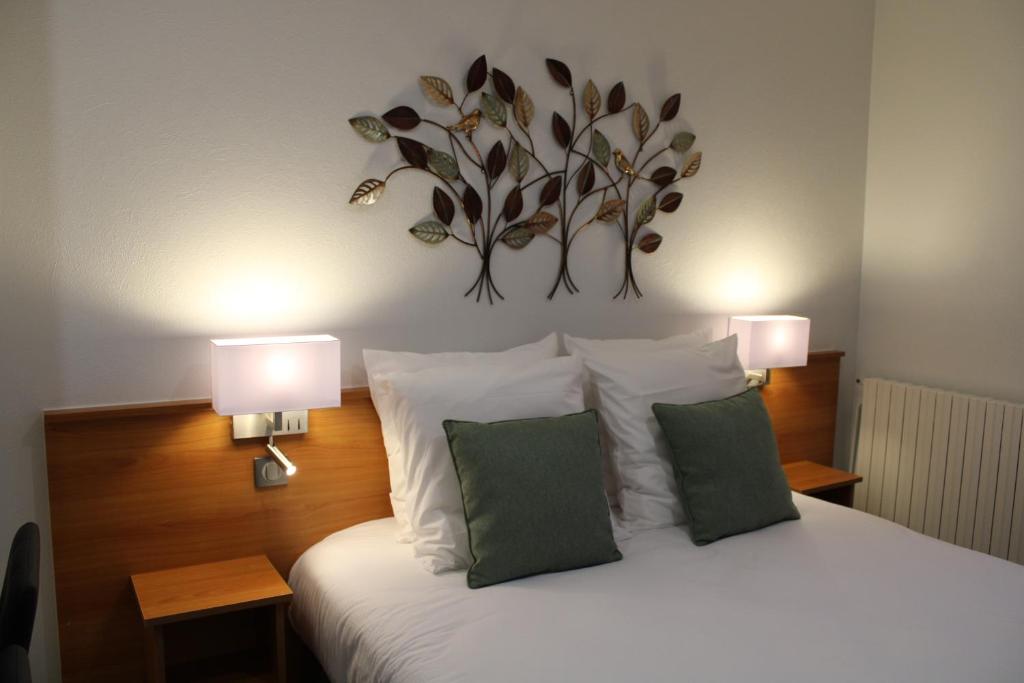 Jaligny巴黎之家酒店的一间卧室配有一张带两盏灯的床。