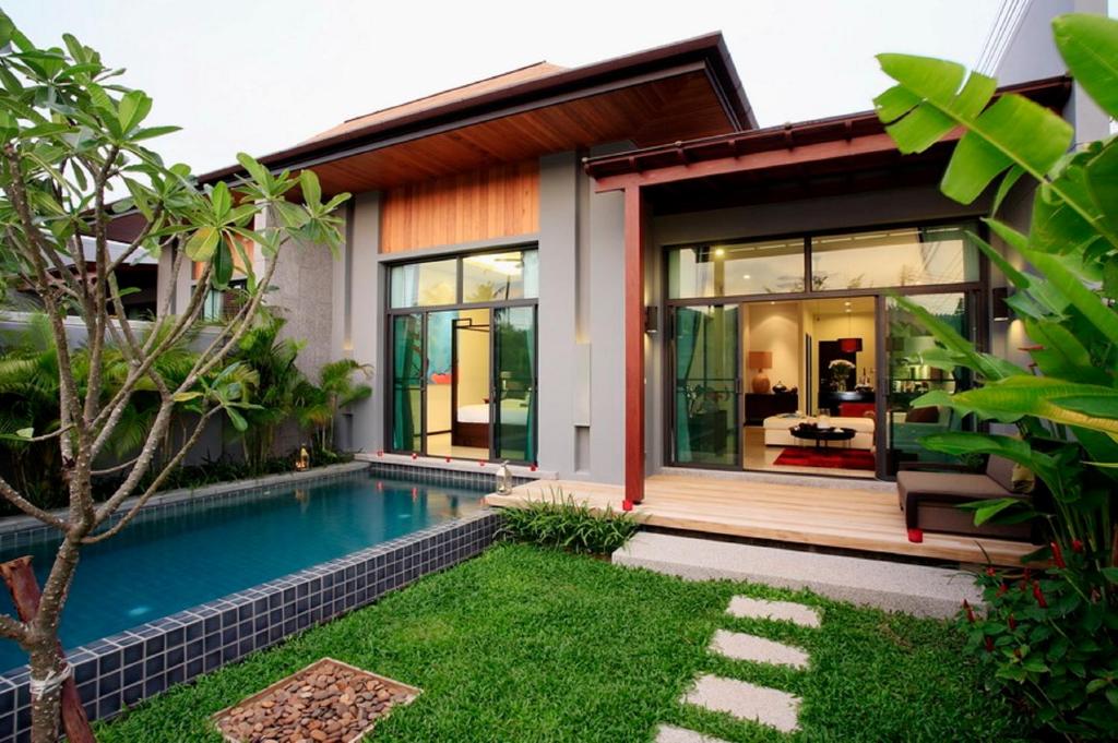 奈汉海滩Two Villas HOLIDAY - Onyx Style Nai Harn Beach, Phuket的一座带游泳池和房子的别墅