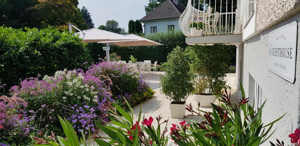 萨尔茨堡利特尔住宿加早餐旅馆的一座花园,旁边是一座花卉和植物