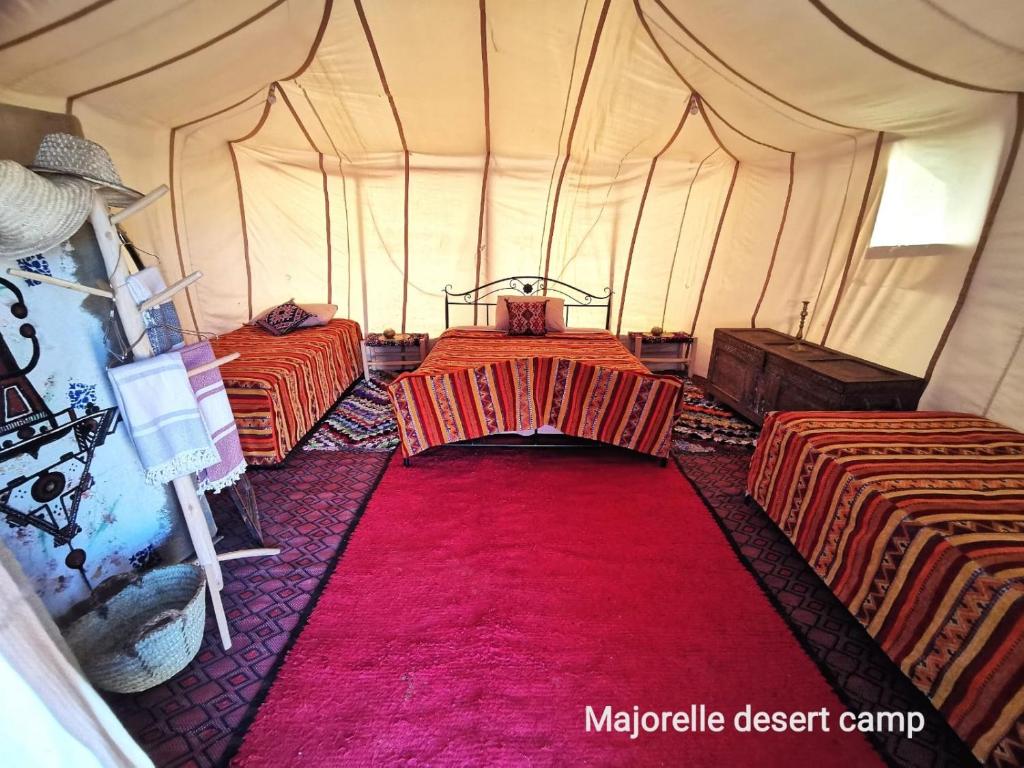 扎古拉Majorelle Desert Camp的一个带两张床和红地毯的帐篷