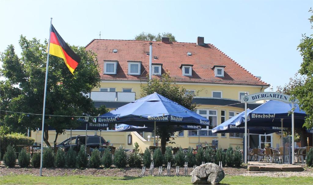 卡塞尔Gasthaus Neue Mühle的大楼前的旗帜和遮阳伞
