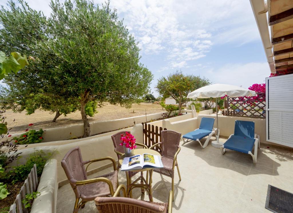 圣费兰-德瑟斯罗Es Garrovers - Formentera Break的庭院配有桌椅和遮阳伞。