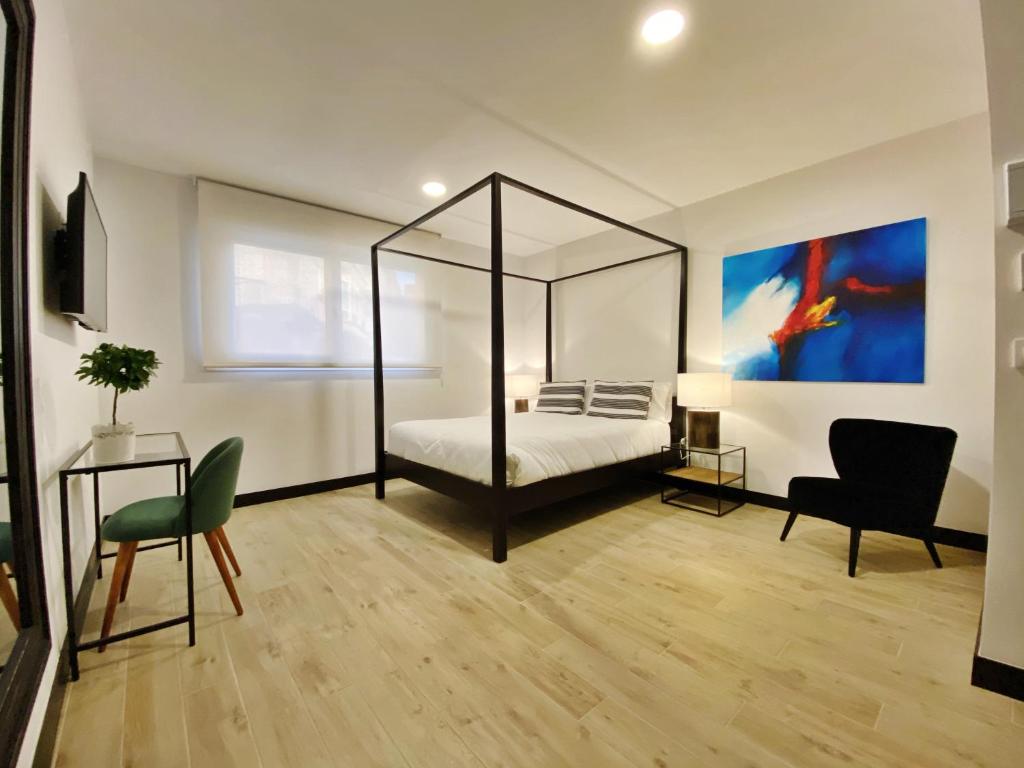图伊La SIGRINA Tuy的一间卧室配有天蓬床和桌椅
