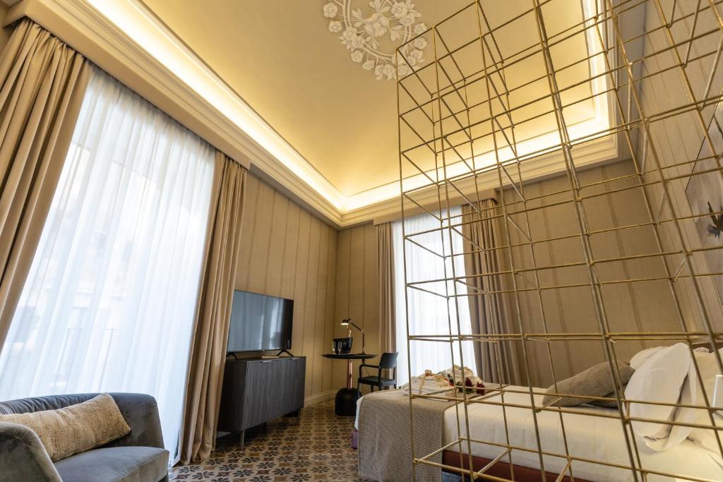 卡塔尼亚B&B Palazzo Perrotta的一间酒店客房,配有一张床和一台电视