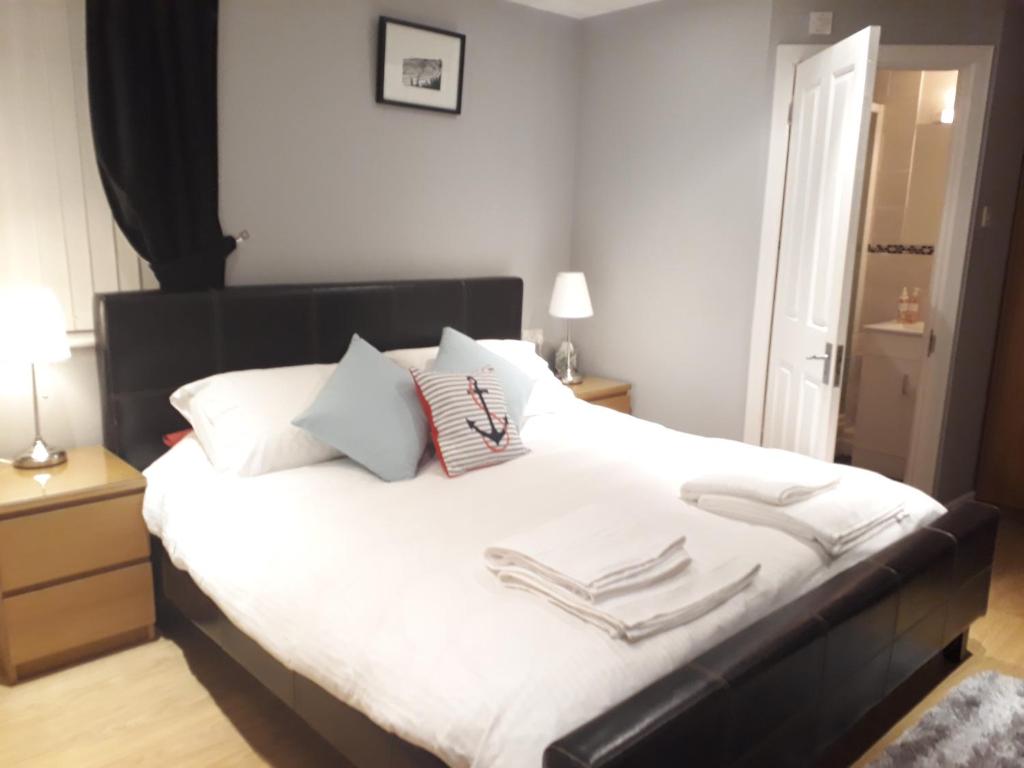浦耳Coast 77 B&B的卧室配有一张带白色床单和枕头的大床。