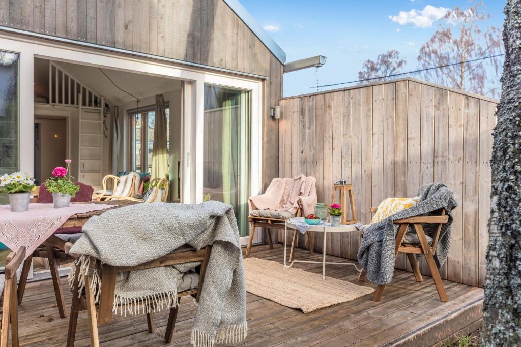 斯德哥尔摩Sparkling newly built house close to city & nature的木制甲板上配有桌椅的天井