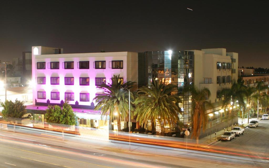 洛杉矶花园套房酒店和度假胜地的夜幕降临的街道,有建筑和棕榈树
