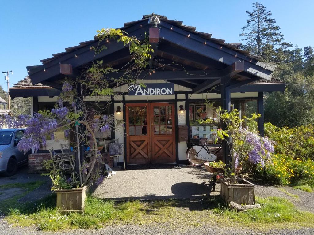 Little RiverThe Andiron Seaside Inn & Cabins的一间有木门和紫色花卉的商店