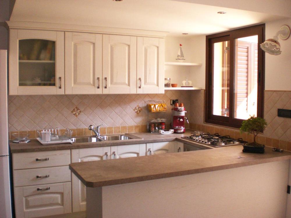 萨尔维一室公寓的厨房配有白色橱柜、水槽和炉灶。