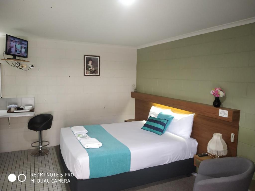 奥尔伯里奥尔伯里中心汽车旅馆的配有一张床和一把椅子的酒店客房