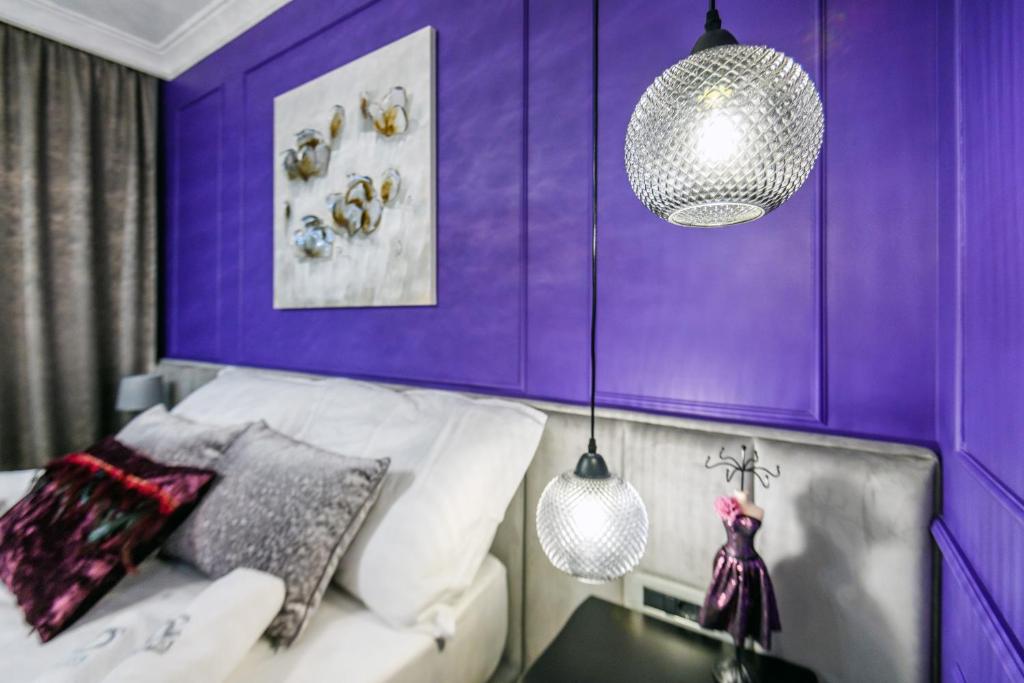 扎达尔DiVine Luxury Apartment Purple的紫色的客房配有一张沙发和一张桌子