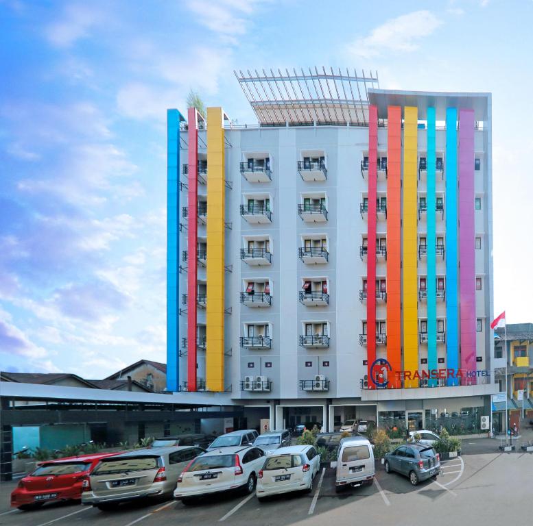 坤甸坤甸特蓝瑟雷酒店的停车场内停放汽车的大型建筑