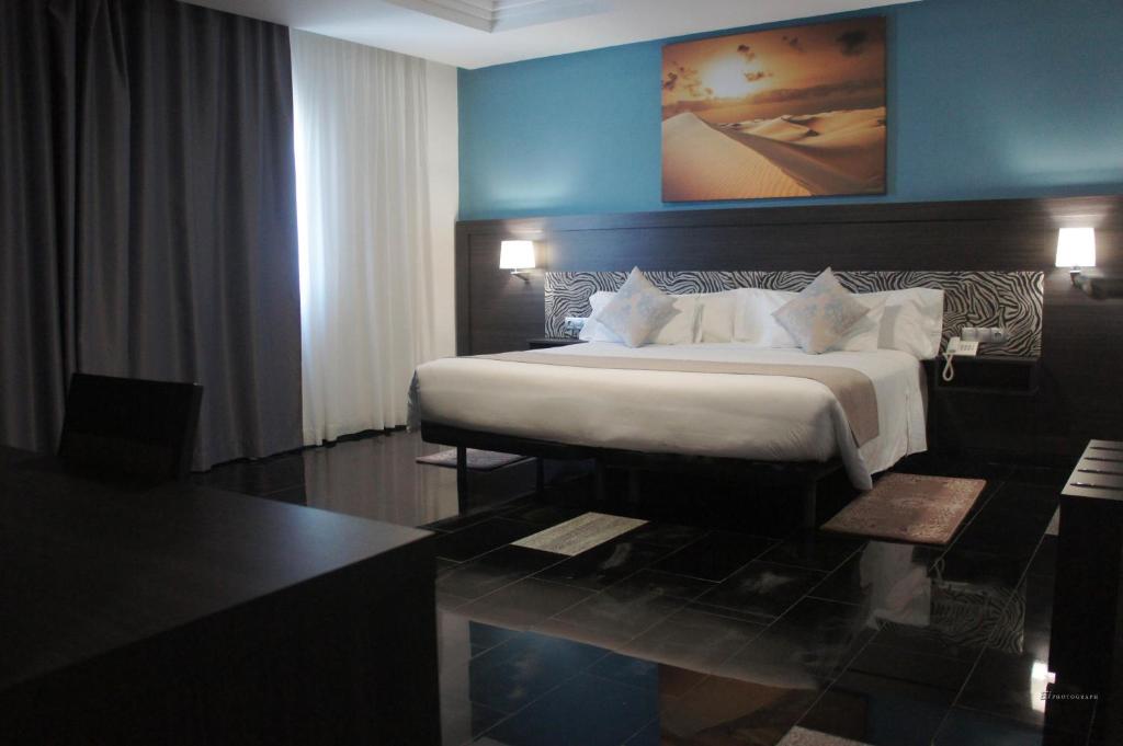 努瓦迪布塔西亚斯特酒店 的一间卧室设有一张大床和蓝色的墙壁