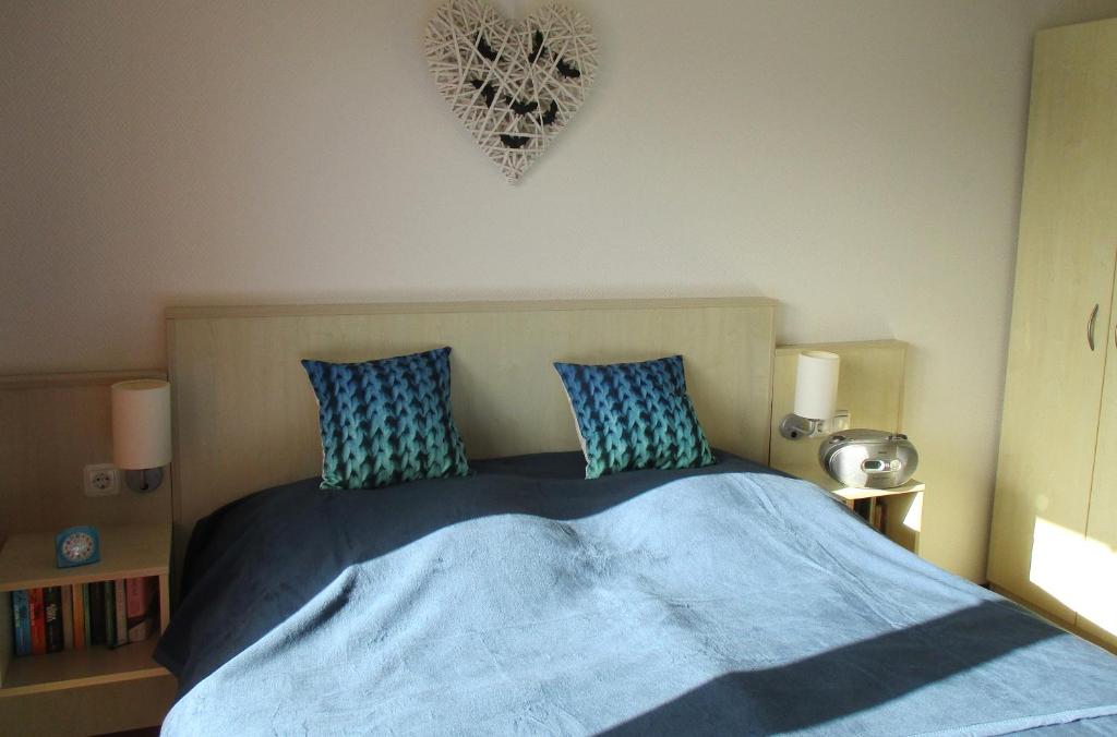 格拉尔-米里茨Apartment Fledermäuschen的一间卧室配有一张带蓝色床单和枕头的床。