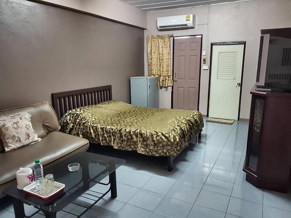 曼谷Million Mansion的一间卧室配有一张床、一张沙发和一张桌子