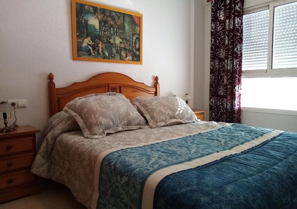 滨海罗克塔斯Precioso piso en Roquetas de Mar的一间卧室设有一张大床和一个窗户。