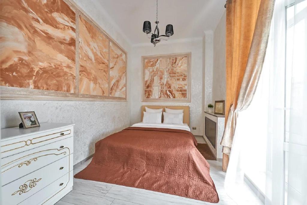 戈梅利PaulMarie Apartments on Prs. Lenina, 19的卧室配有一张床,墙上挂有绘画作品