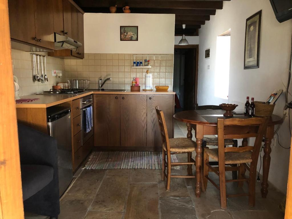 Episkopi PafouANOI 1-bedroom country House的厨房配有木桌和桌椅