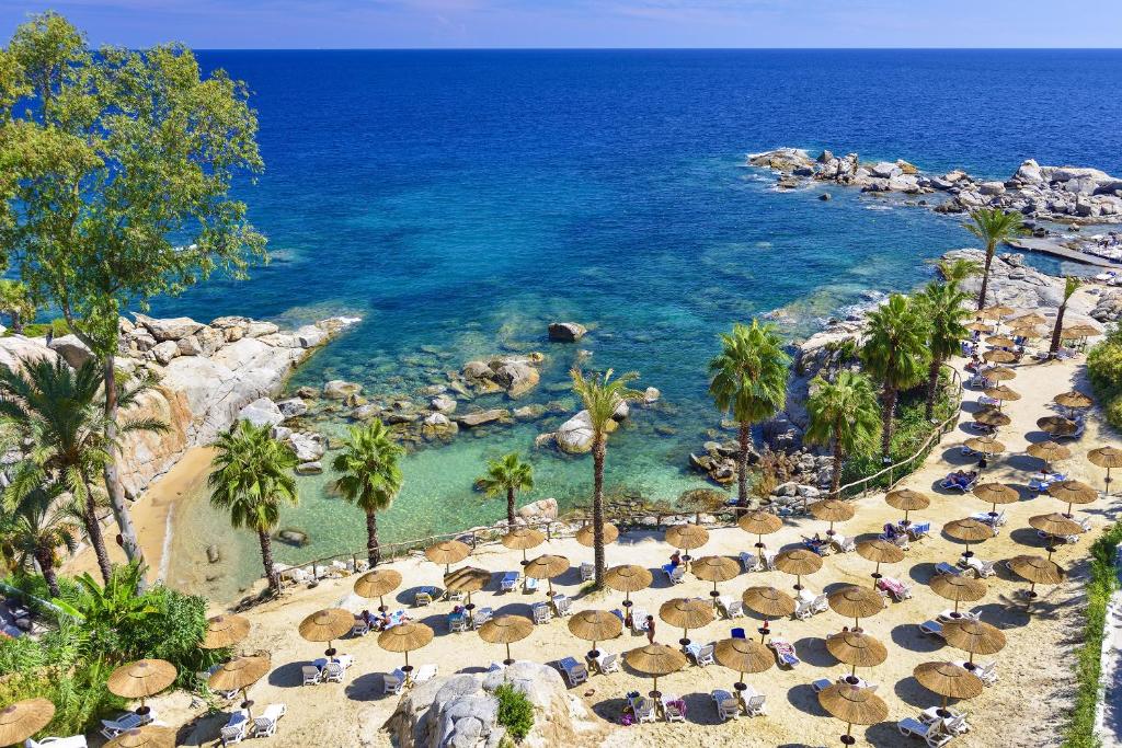 阿尔巴塔克斯阿尔巴塔克斯公园别墅度假酒店的海滩上设有椅子和遮阳伞,还有大海