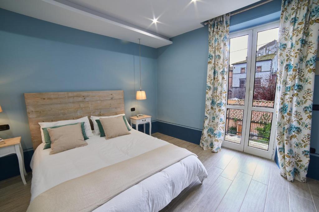 维泰博AL22 di piazza del Gesù的蓝色的卧室设有一张大床和一个窗户