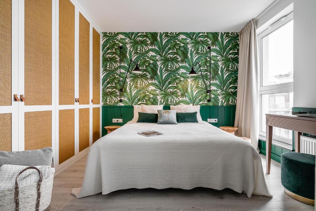 格但斯克Apartament Ap175的一间卧室配有一张带花卉壁纸的大床