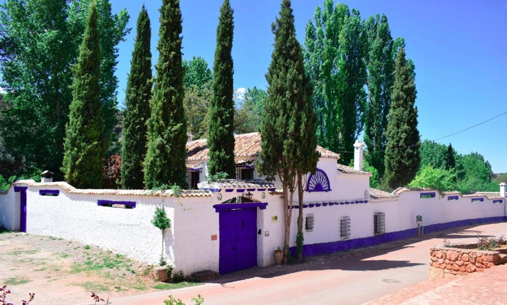 奥萨德蒙铁尔Venta del Celemín的白色的房子,有紫色的门和树木