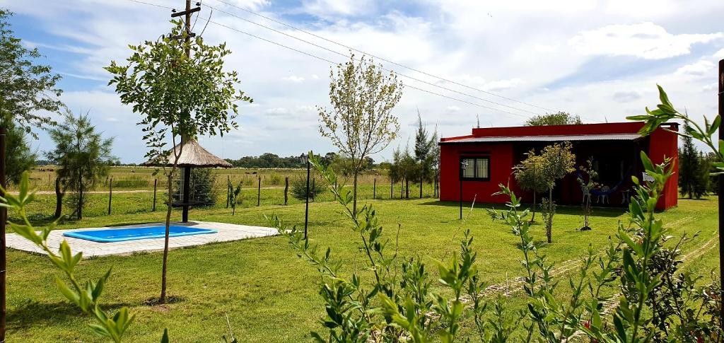 乌里韦拉雷亚La Maina Uribe的一座红色的小房子,在院子里设有游泳池