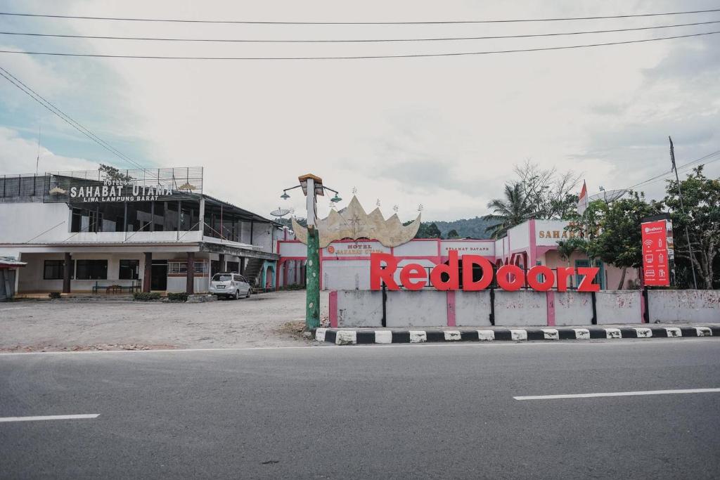 LampungRedDoorz Syariah near Kebun Raya Liwa的红门标牌的城镇街道