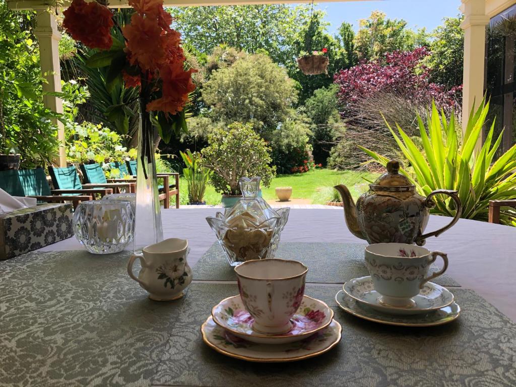 TamahereEnglish Cherry Tree Manor的茶杯和花瓶上的桌子