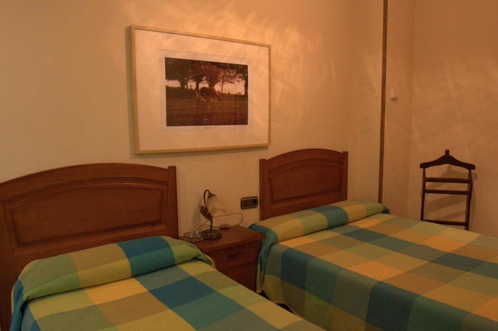 莱昆韦里埃洛斯塔乡村旅馆的卧室配有两张床,墙上挂着一幅画