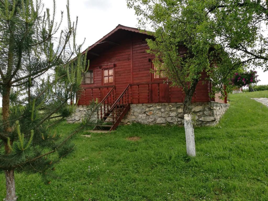GârnicPensiunea Gernik 100的小木屋,设有石墙和一棵树