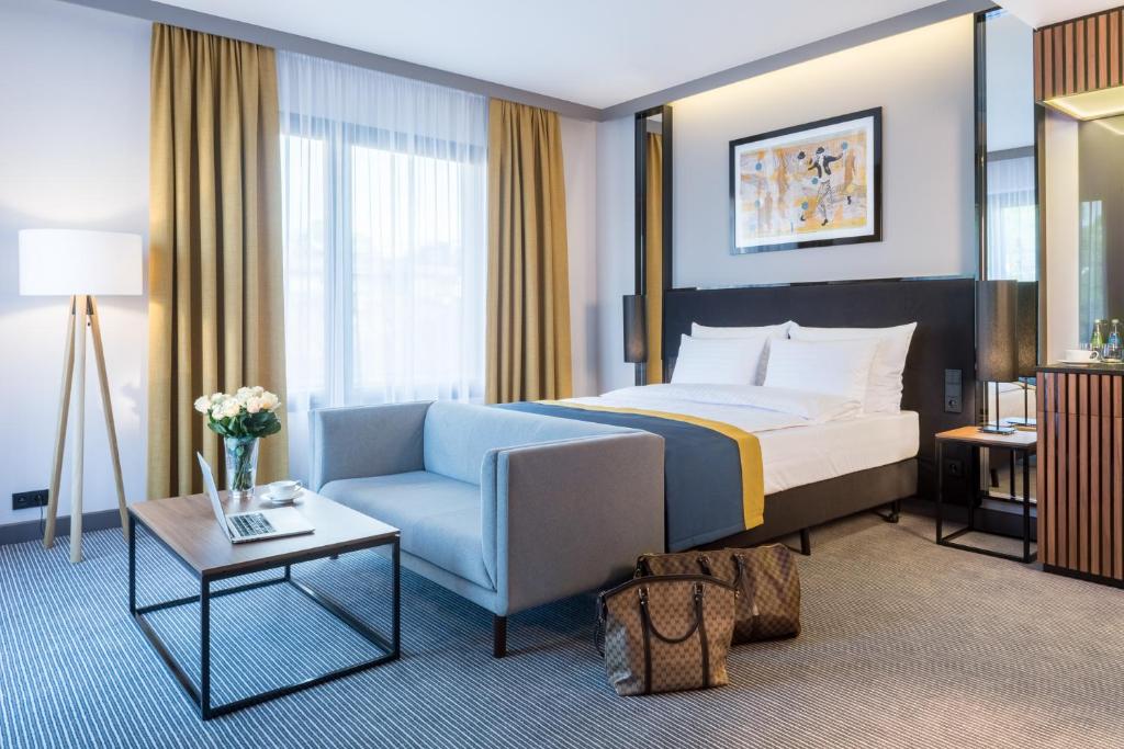 克拉科夫阿斯科特大酒店的配有一张床和一把椅子的酒店客房