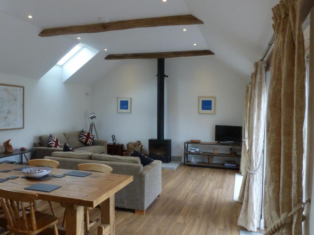 格拉斯顿伯里The Woodshed - A newly built, 2 bedroom, cottage near Glastonbury的客厅配有桌子和沙发
