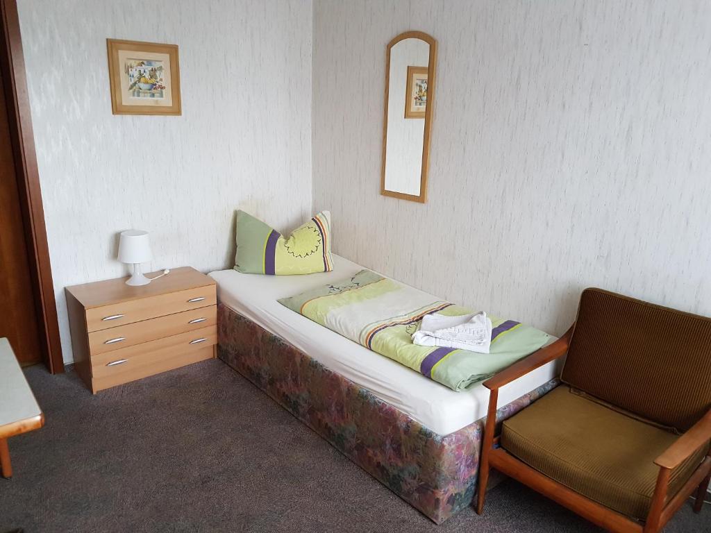 根廷Hotel Arkona的一张小床和一把椅子